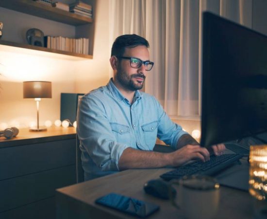 Man working remotely from home at night